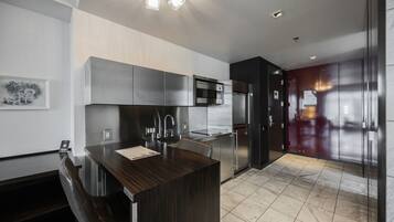 Una cocina moderna con una isla central, electrodomésticos de acero inoxidable y una encimera de madera oscura.