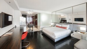 A modern hotel room with a large bed, a desk, a chair, a TV, and a mirror. - Strip View Studio • Balcony • No Resort Fee • Free Parking • TE25 (Las Vegas)