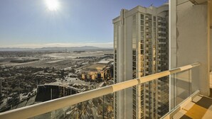 A high-rise building with multiple balconies, a clear view of the cityscape, and a sunlit sky.