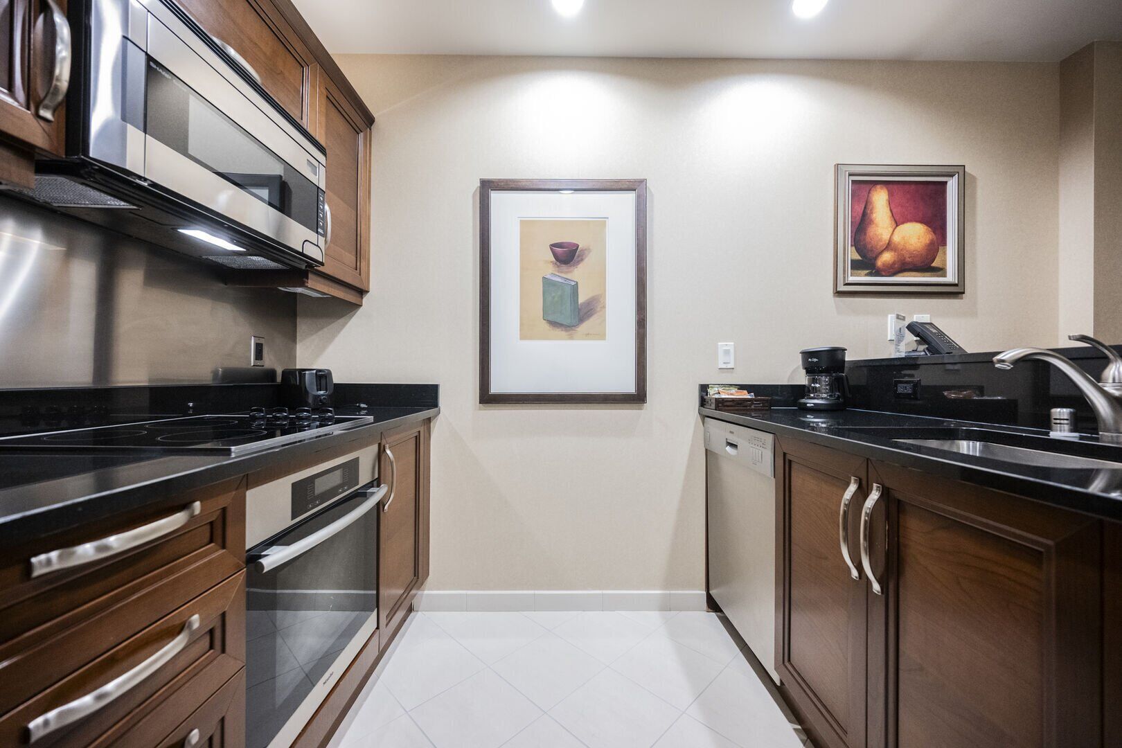 Uma cozinha moderna com eletrodomésticos de aço inoxidável, armários de madeira e piso revestido.
