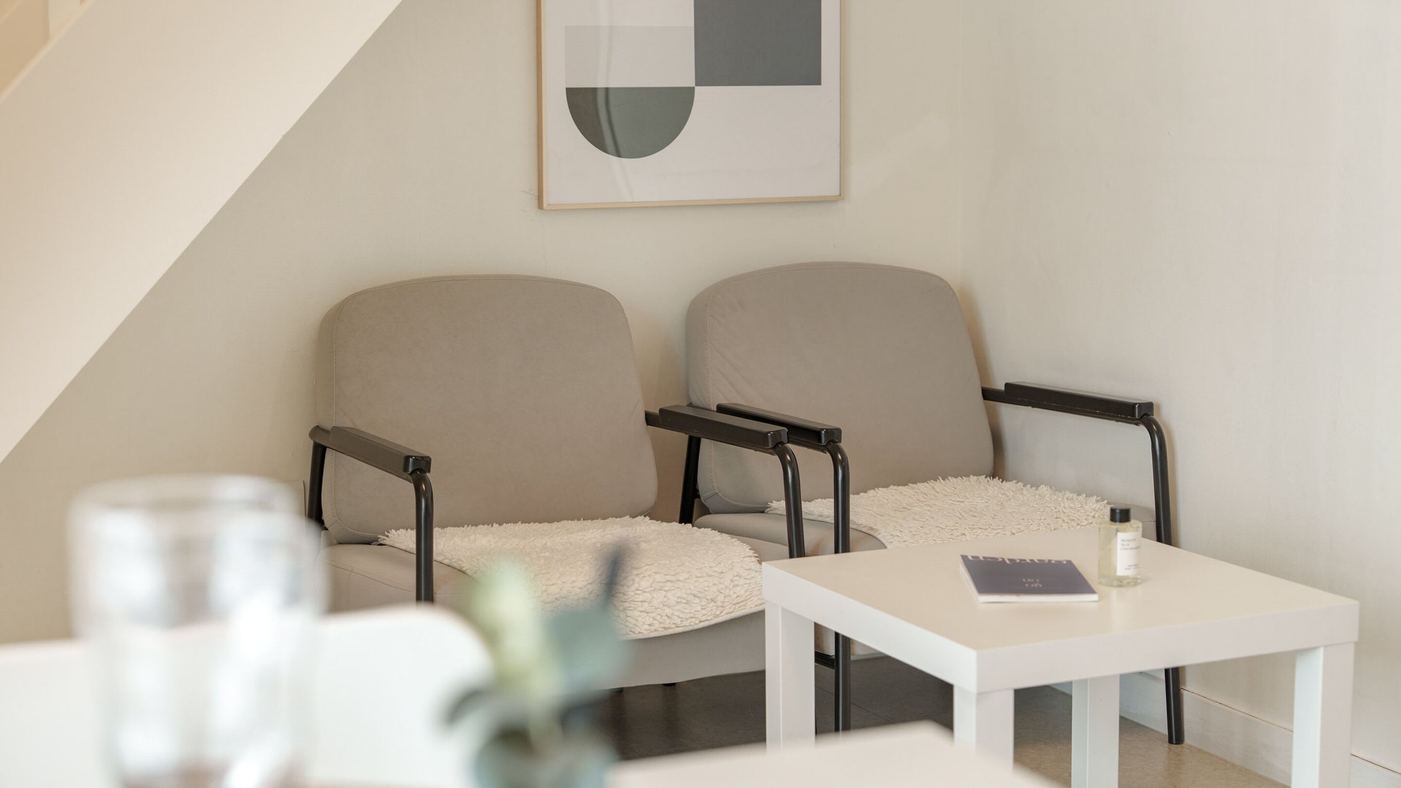A modern, minimalist room with two chairs and a small table.