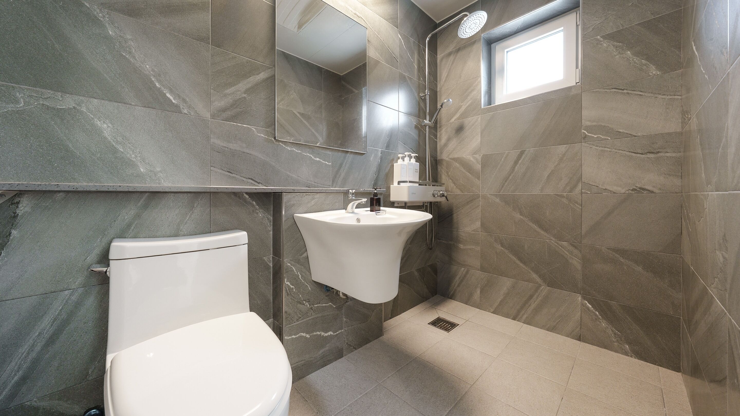 Un baño moderno con inodoro, lavabo y ducha.