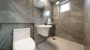Un baño moderno con inodoro, lavabo y ducha.