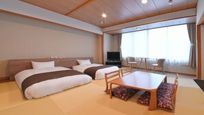 Une chambre d’hôtel avec deux lits, une télévision, une table à manger et une vue sur l’extérieur.