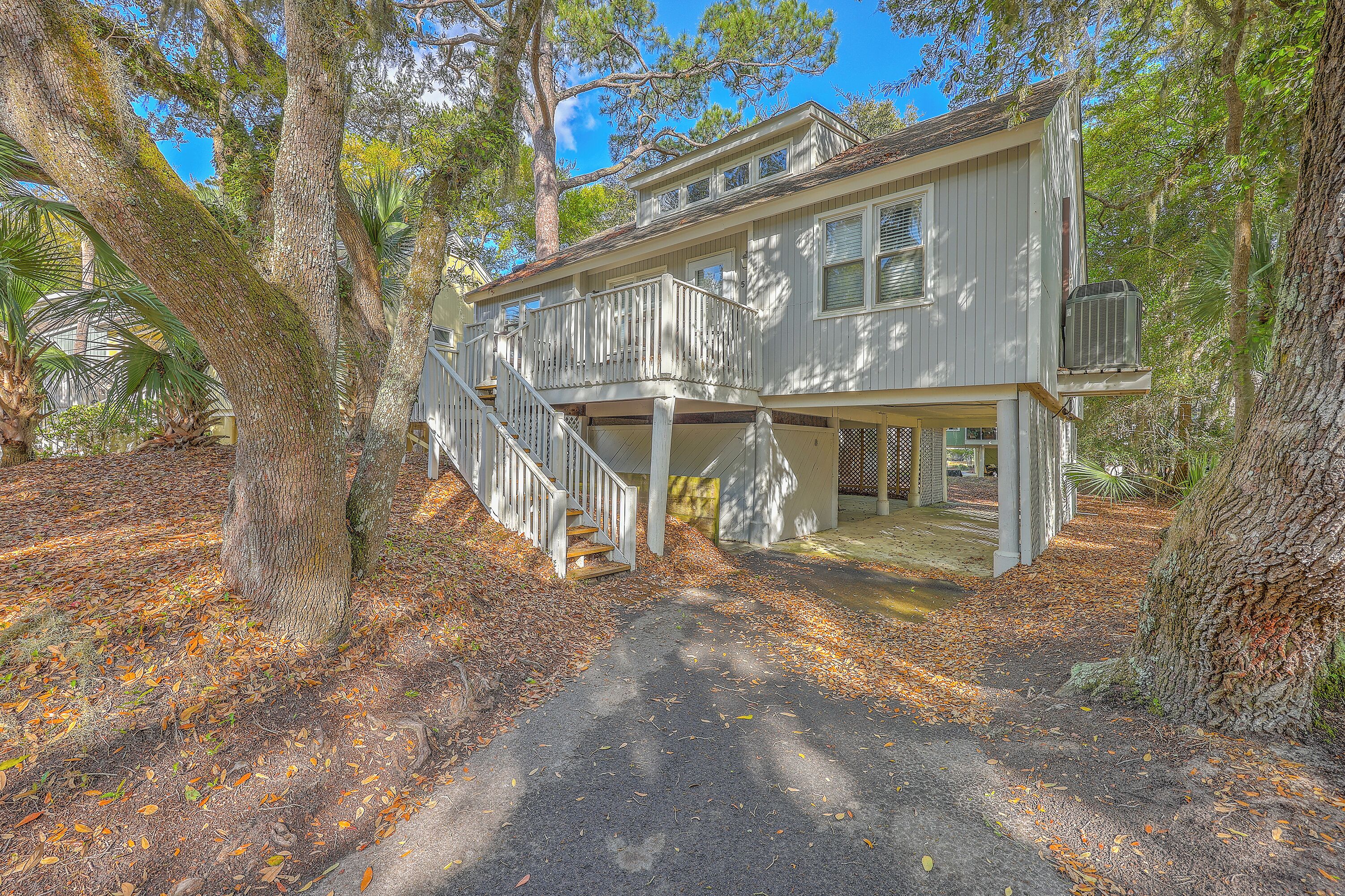 A two-story house with a covered porch and a staircase leading to the upper floor.