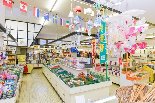 Een helder verlichte winkel met diverse producten op planken en hangende versieringen.
