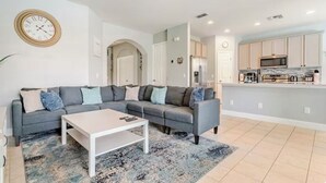 A modern living room with a grey sectional sofa, a white coffee table, and a patterned rug. - Spacious 4-bedroom villa in nice Kissimmee Florida (Kissimmee)