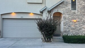 A two-story house with a stone facade, a garage, and a well-maintained front yard. - Wyngate Retreat Mtn view home, BBQ, 4 bed, 17 Mi from Snowbird. (South Jordan)