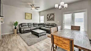 A modern living room with a sectional sofa, a dining table, and a ceiling fan. - Wyngate Retreat Mtn view home, BBQ, 4 bed, 17 Mi from Snowbird. (South Jordan)