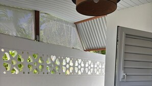 Un coin repas avec une table grise et des chaises noires, un mur décoratif orné de motifs en forme de cœur et une porte coulissante.