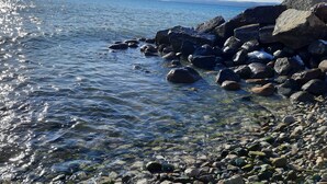 Una costa rocosa con aguas cristalinas que reflejan la luz del sol.