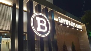 La façade de l’hôtel Brown Dot, avec son logo « B » illuminé, bien visible.
