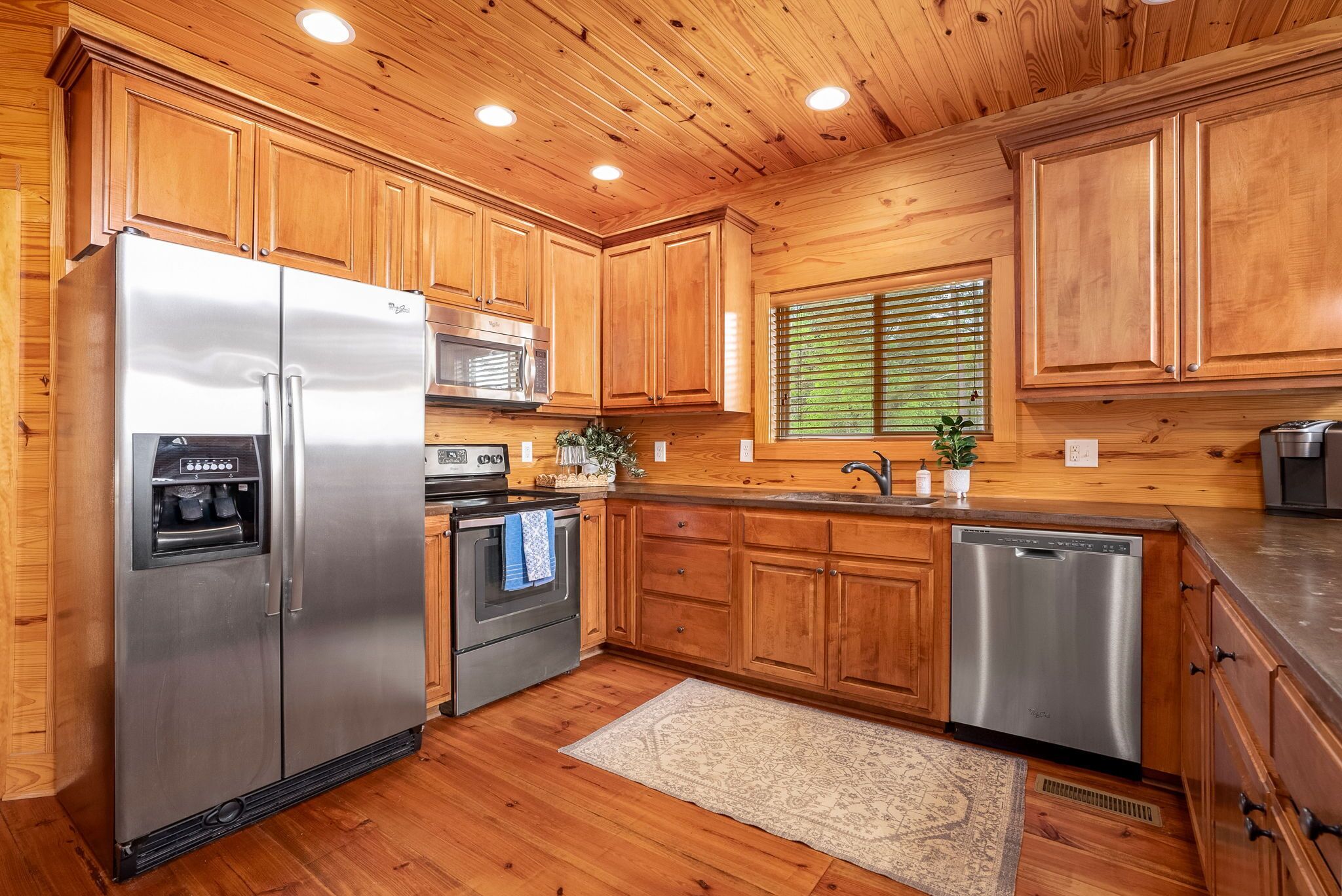 Una cocina moderna con armarios de madera, electrodomésticos de acero inoxidable y un dispensador de agua integrado.