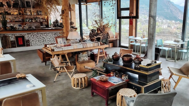 A spacious lounge area with a bar, comfortable seating, and a view of mountains. - LaMaiSon (Garze)