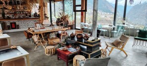 A spacious lounge area with a bar, comfortable seating, and a view of mountains.