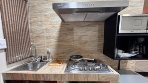 A compact kitchen with a sink, stove, and a microwave.