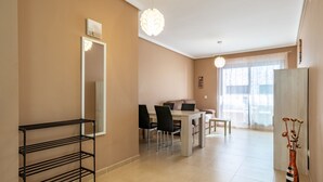 Un salon moderne comprenant un coin repas, un grand miroir et un vase décoré de fleurs séchées.