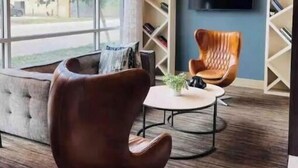 Een moderne woonkamer met een bank, een salontafel en een aan de muur bevestigde televisie.