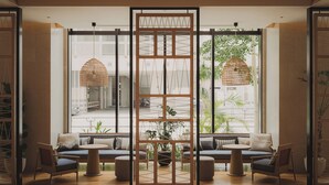 A modern interior with a seating area, large windows, and hanging wicker lamps. - THE NEST NAHA (Naha)
