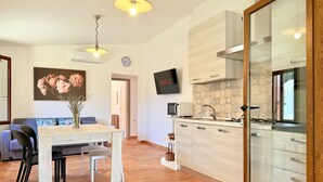 Eine moderne Küche mit Mikrowelle, Herd und einem an der Wand befestigten Fernseher.