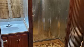 Een douche, handdoeken, zeep, toiletpapier