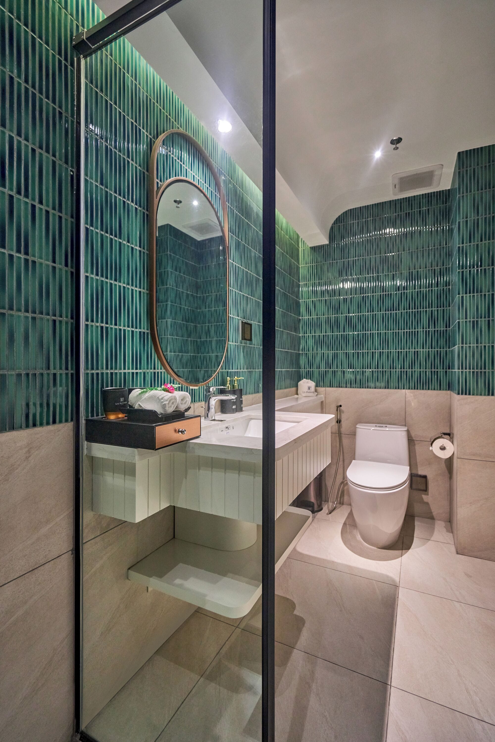 A modern bathroom with a glass-enclosed shower, a sink with a towel rack, and a toilet.