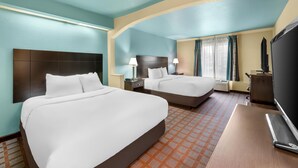A hotel room with two beds, a desk, a TV, and a window with curtains. - Red Lion Inn & Suites Blue Springs (Blue Springs)