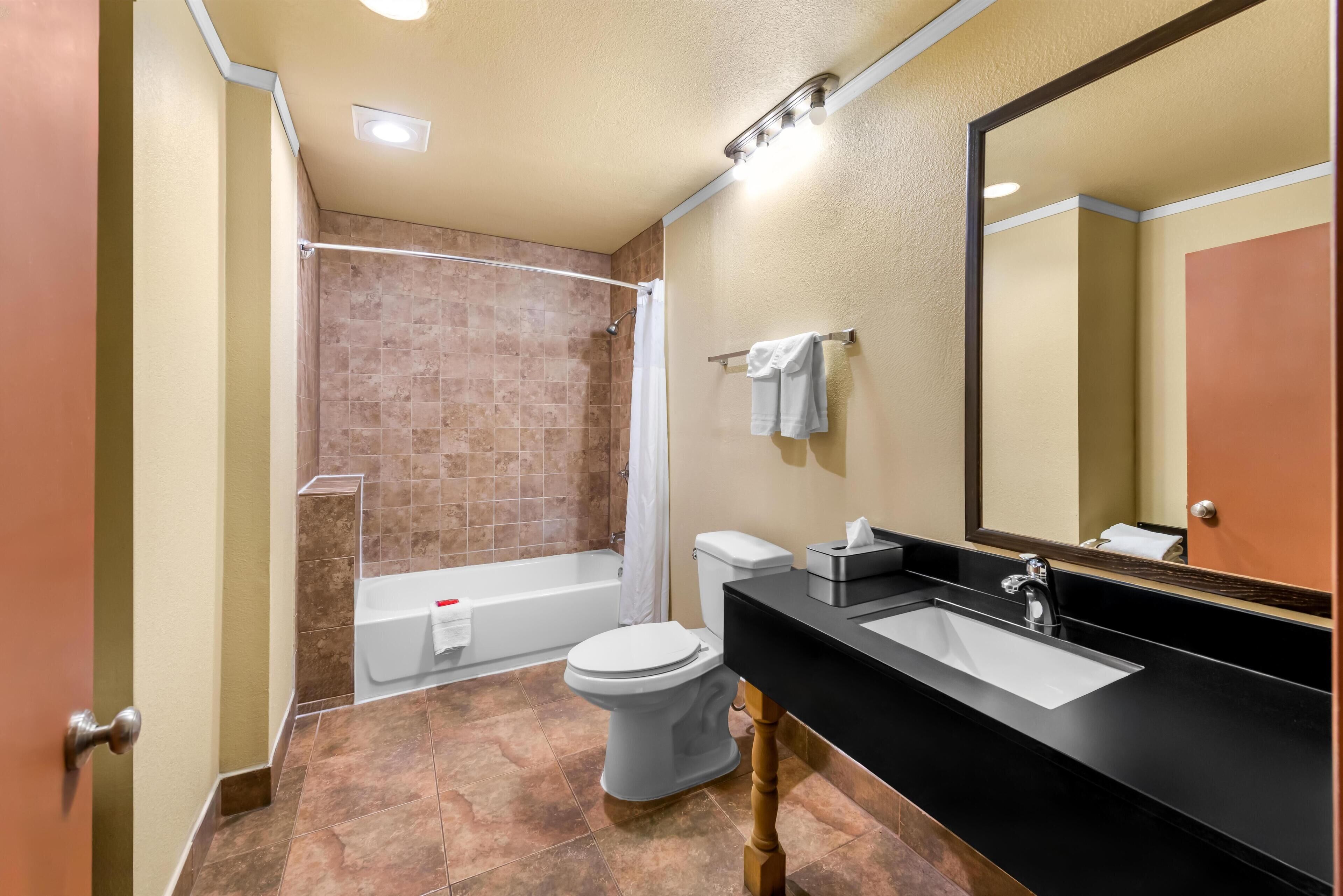 A modern bathroom with a bathtub, toilet, and sink.