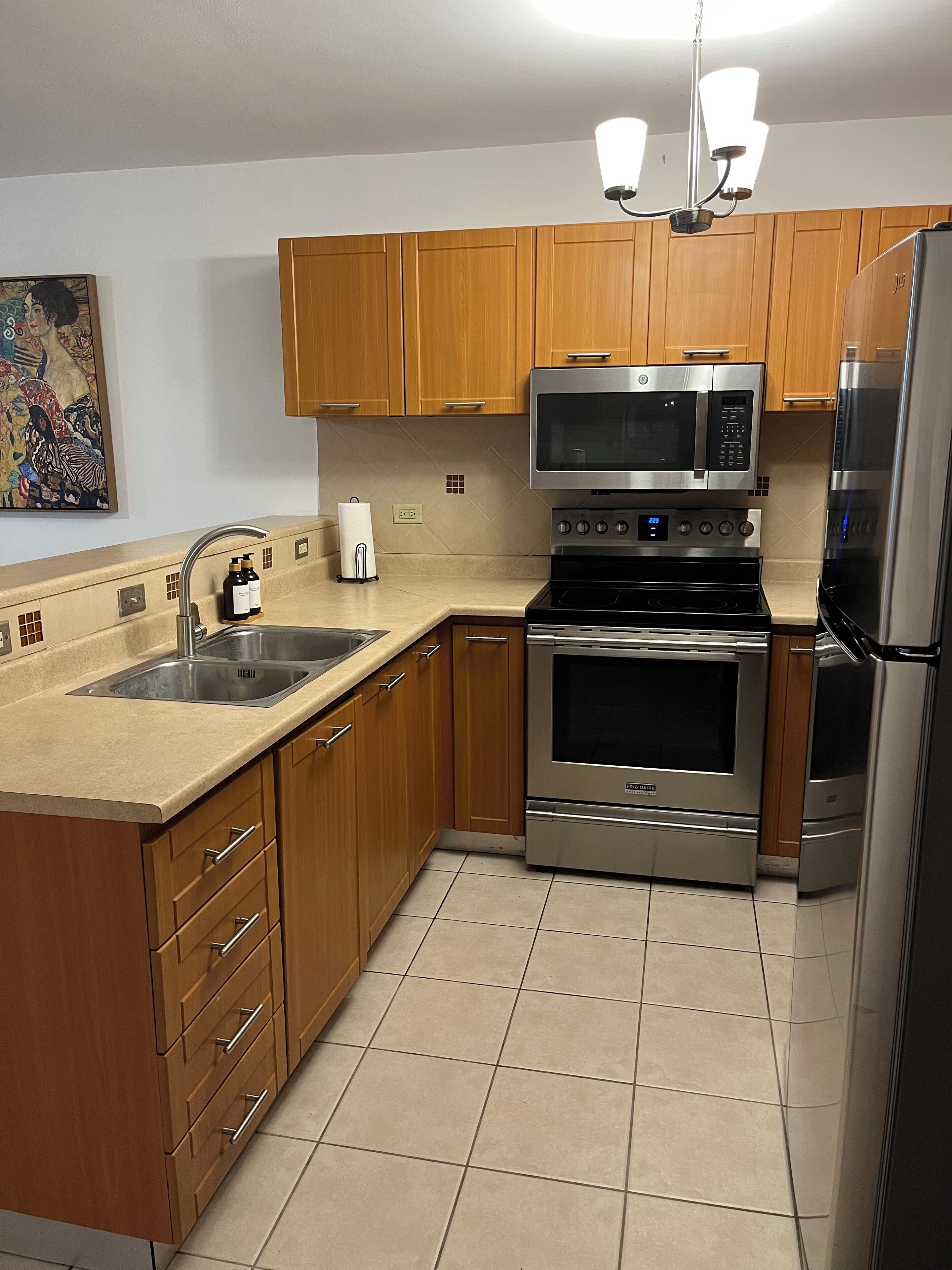 A modern kitchen with wooden cabinets, stainless steel appliances, and a tiled backsplash.