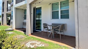 Un appartement moderne doté d’un balcon, d’un espace salon extérieur et de guirlandes lumineuses.