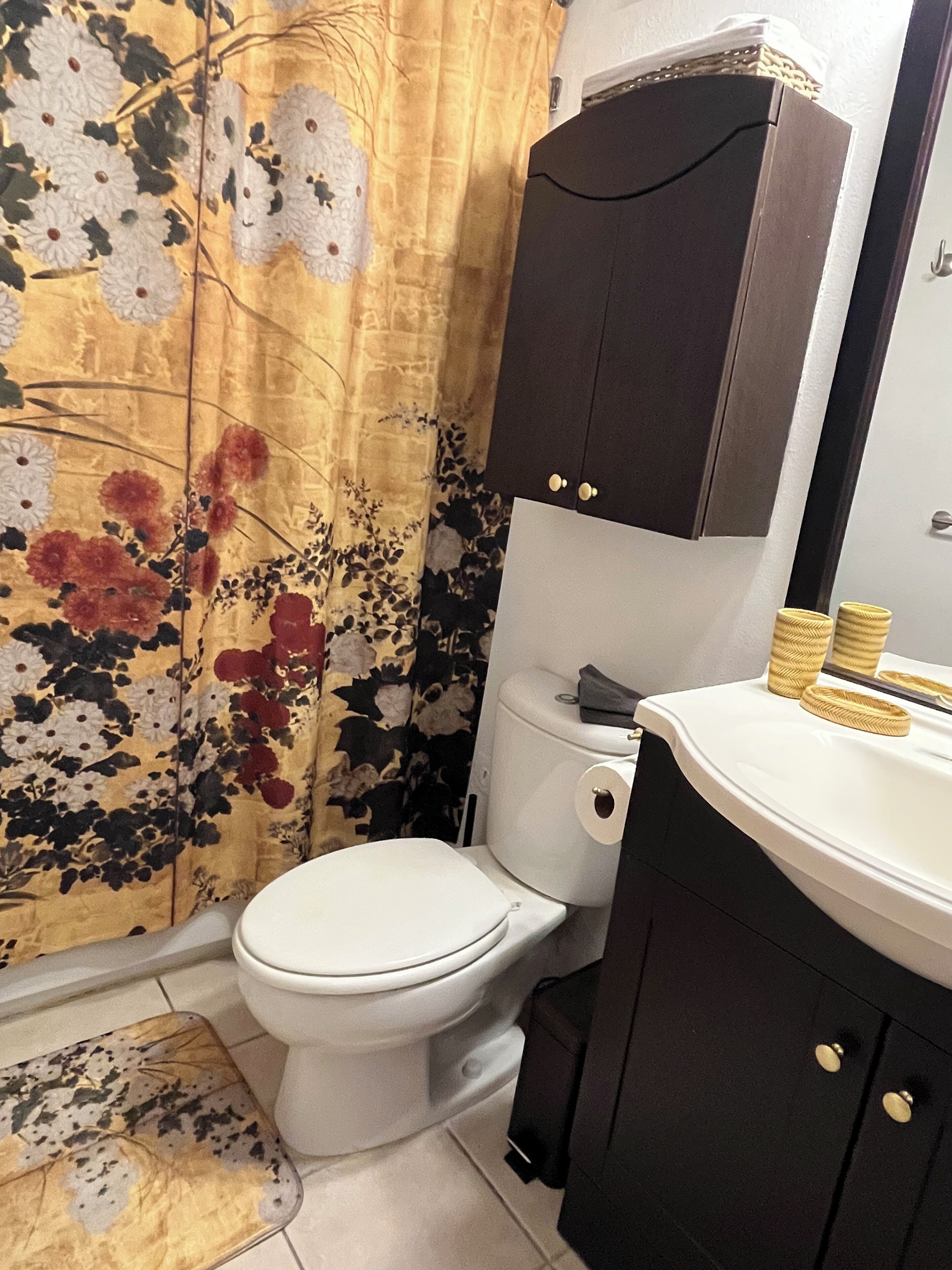 A bathroom with a toilet, a sink, and a cabinet.