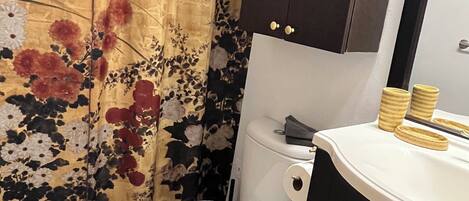 A bathroom with a toilet, a sink, and a cabinet.