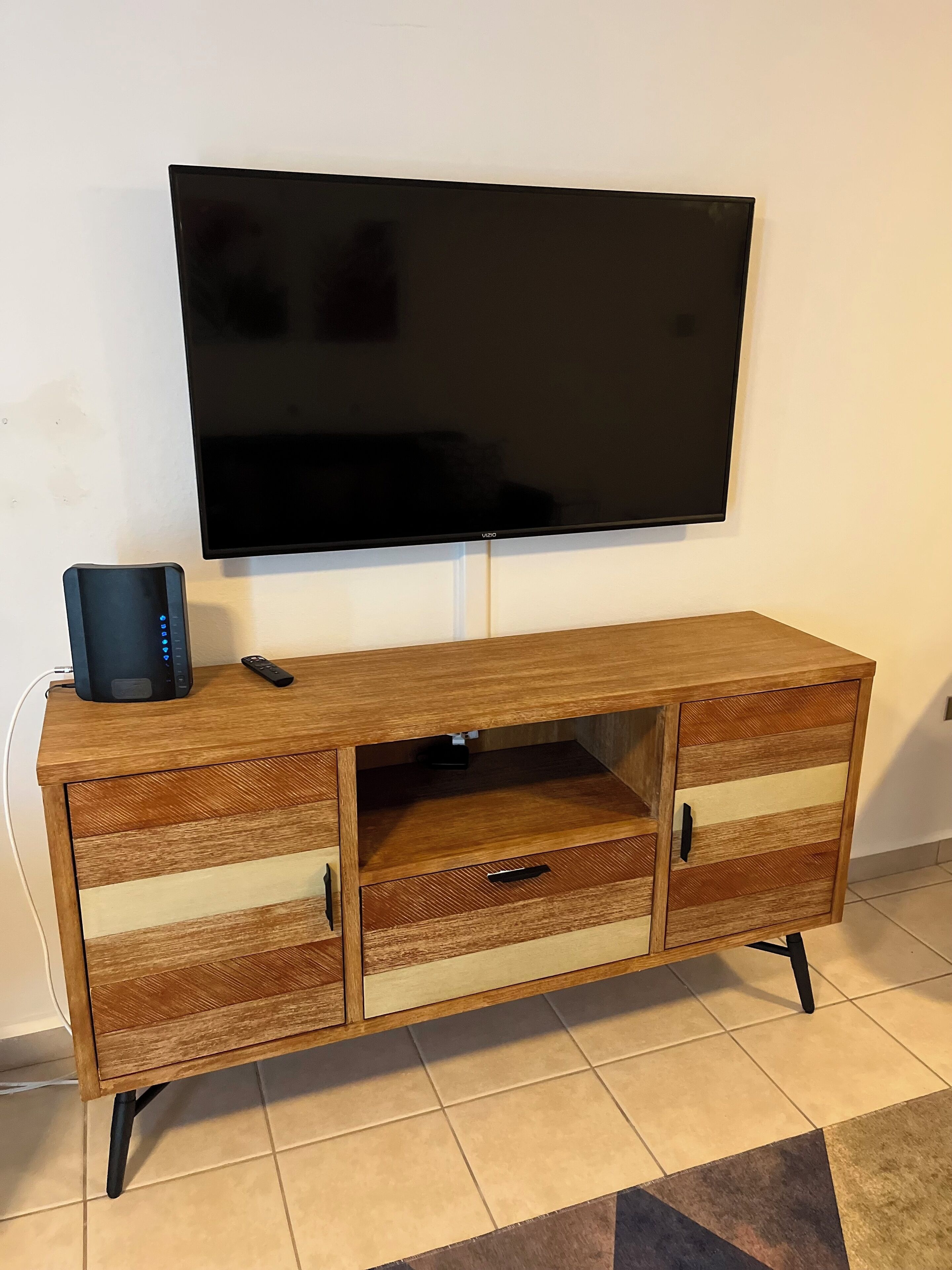 A wooden entertainment center with a flat-screen TV mounted above it.