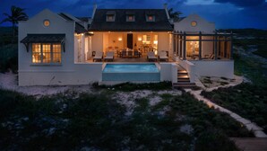 A beachfront house with a pool, outdoor seating, and a covered patio. - 4 BR All-Inclusive Villa @ Ambergris Cay: Aurora (Big Ambergris Cay)