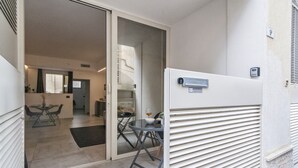 Un apartamento moderno con puerta corrediza de vidrio que da a un comedor con mesa y sillas.