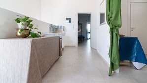 Moderni keittiö, jossa on työtaso, pesuallas ja ruukkukasvi.