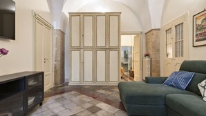A living room with a green sofa, a flat-screen TV, and a tiled floor. - Fanfulla Court - Lecce Selection (Lecce)