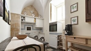 A cozy kitchen with a stone arch, a coffee machine, and a tiled floor. - Fanfulla Court - Lecce Selection (Lecce)