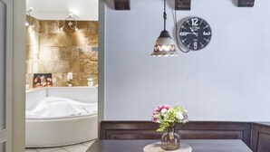 A bathroom with a bathtub, a clock, and a vase with flowers on a table. - Baglivi 17 - Lecce Selection (Lecce)