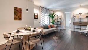 A modern living room with a round dining table, sofa, and a bookshelf. - HON Lecce Hospitality - Lecce Selection (Lecce)