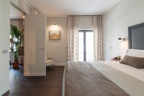 Ein Schlafzimmer mit Bett, Nachttisch, Lampe, einem Bild an der Wand und einem Fenster mit Vorhängen.