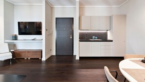A modern kitchen with white cabinets, a dark door, and a built-in oven. - HON Lecce Hospitality - Lecce Selection (Lecce)