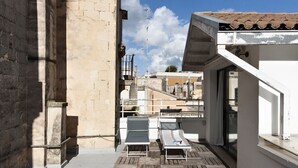 A rooftop terrace with two lounge chairs, a view of the cityscape, and a building with a tiled roof. - InCentro Exclusive Terrace Suite - Lecce Selection (Lecce)