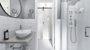 A modern bathroom with a large white sink, a mirror, and a glass-enclosed shower area. - InCentro Exclusive Terrace Suite - Lecce Selection (Lecce)