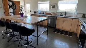 A modern kitchen with a central island, wooden cabinets, a dishwasher, and a stove. - Casa de Los sueños del mañana (El Prado)