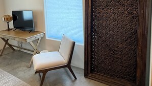 A room with a desk, chair, TV, and a decorative wooden panel. - Casa de Los sueños del mañana (El Prado)