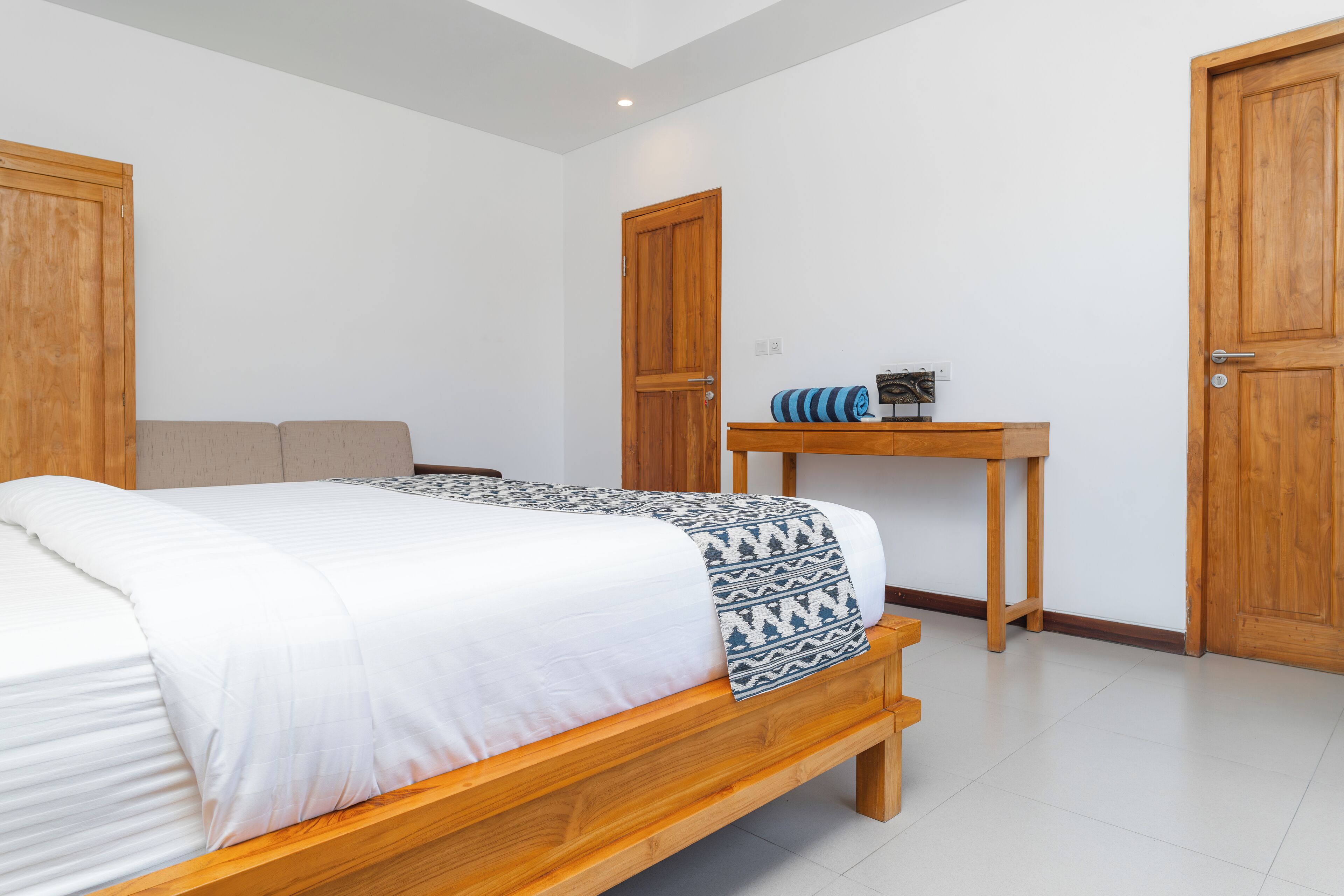 Un dormitorio con una cama de madera, una mesita de noche y dos puertas de madera.