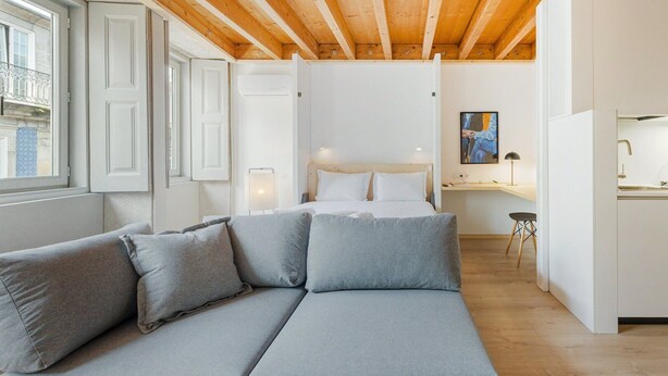 Une chambre à coucher moderne avec un lit, un canapé, un bureau et un tableau.