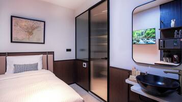 A modern hotel room with a bed, a large mirror, a map on the wall, and a TV.