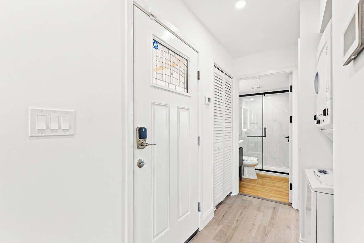 A hallway with white doors, a visible lock, and a light switch.